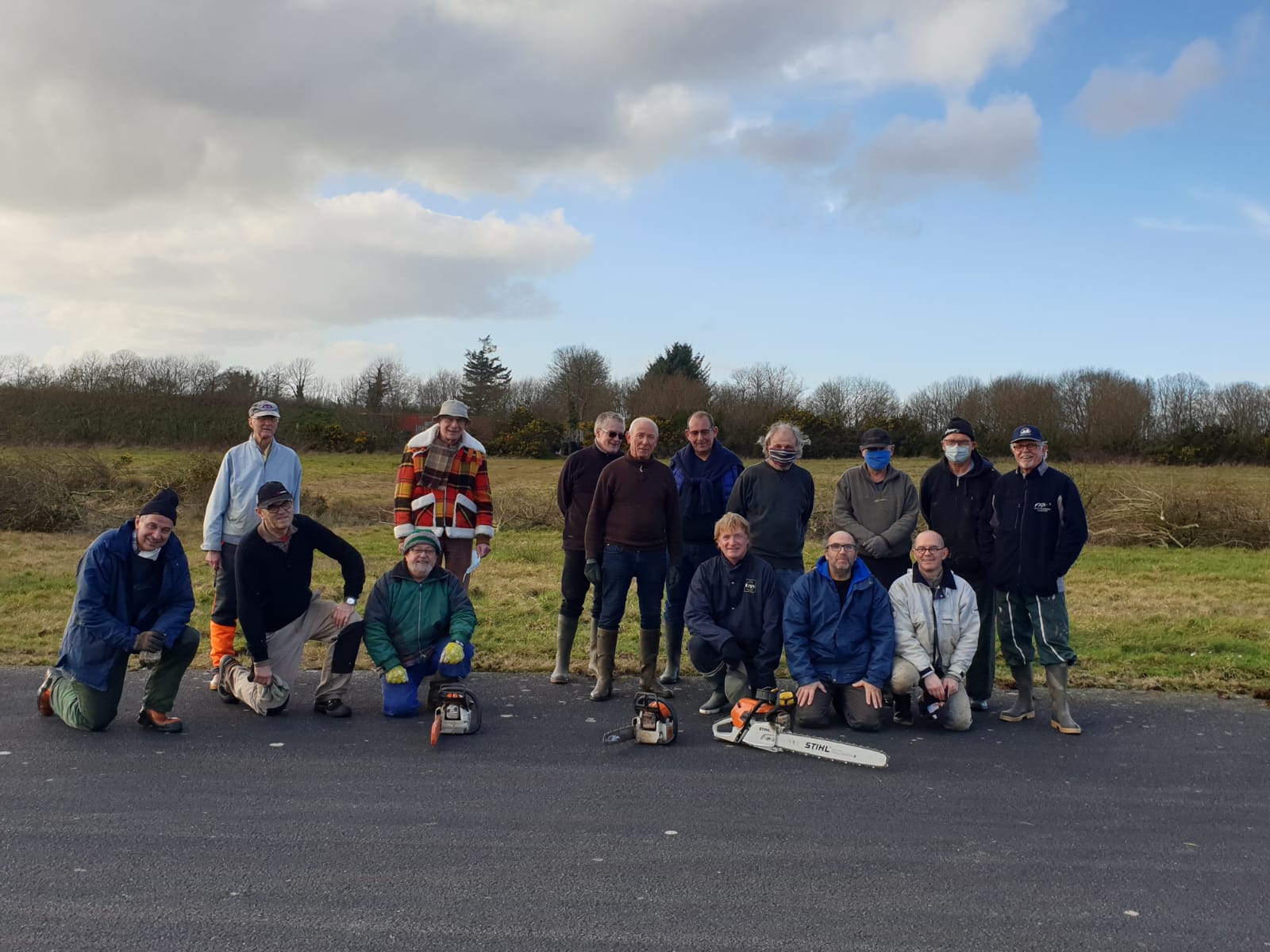 Groupe de bénévoles de l’Aérodrome Bretagne Atlantique effectuant l’entretien du terrain avec tronçonneuses et matériel de coupe.