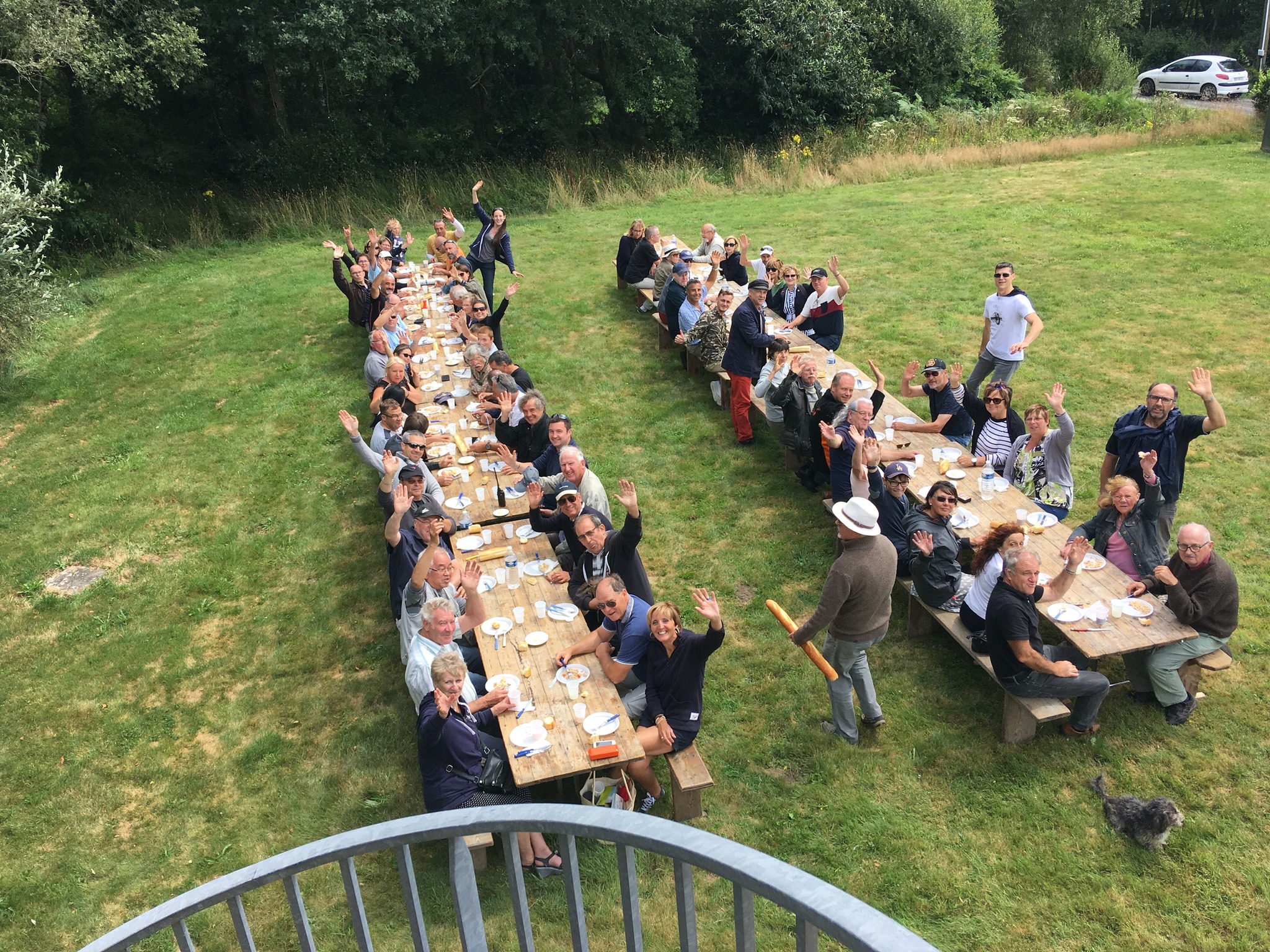 Grande tablée de bénévoles de l’Aérodrome Bretagne Atlantique partageant un repas en plein air, symbole de convivialité et d’esprit communautaire.