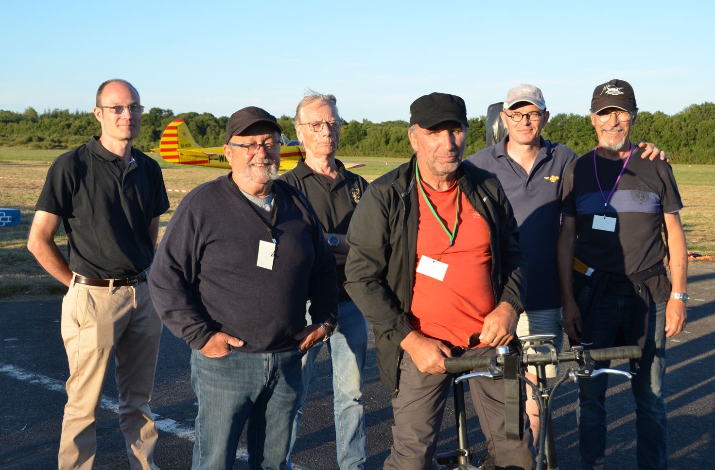 Groupe de bénévoles de l’Aérodrome Bretagne Atlantique en extérieur, devant un avion, engagés dans la gestion et l’entretien de la plateforme aérienne.